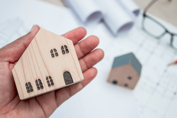 Деревянный дом модели в руке, Концепция строительства дома - Фото, изображение