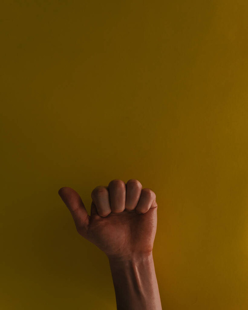 A man giving thumbs up on an isolated yellow background - concept of approval - Foto, afbeelding