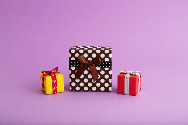 A closeup of colorful gift boxes in the purple background - Φωτογραφία, εικόνα