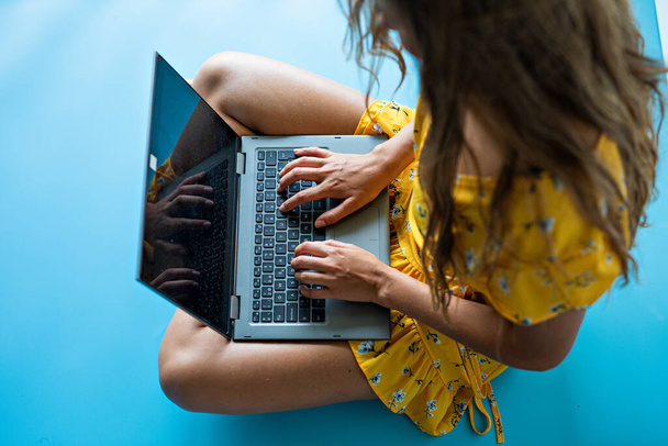 A closeup shot of a young lady working on a laptop - Fotó, kép