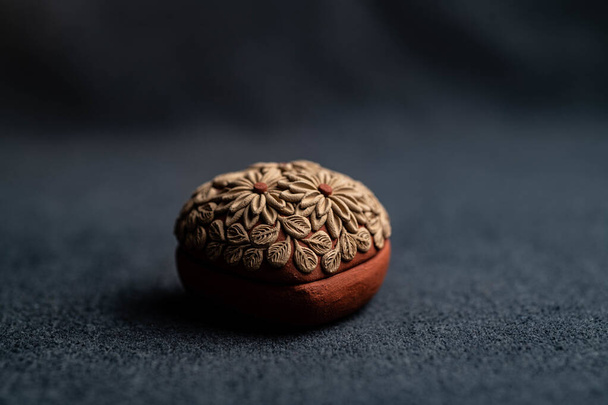 A closeup shot of a clay egg from the state of Oaxaca in Mexico on a soft fabric surface - Foto, Imagem
