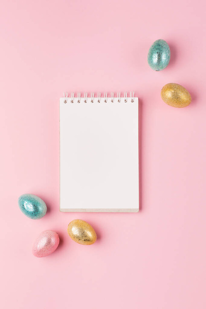 Gold, silver shiny Easter eggs on pink pastel background with space for text. Flat lay image composition, top view. Easter decoration, foil minimalist egg design, modern design template. - 写真・画像