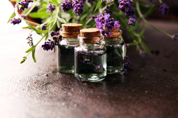 Levendula illóolaj üveg friss levendula virágokkal az egészséges aromaterápiás spa masszázs koncepcióhoz.  - Fotó, kép
