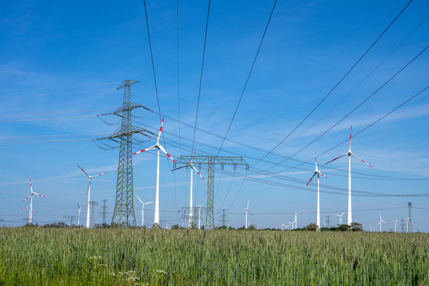 Power lines, electricity pylons and wind turbines seen in Germany - Foto, imagen