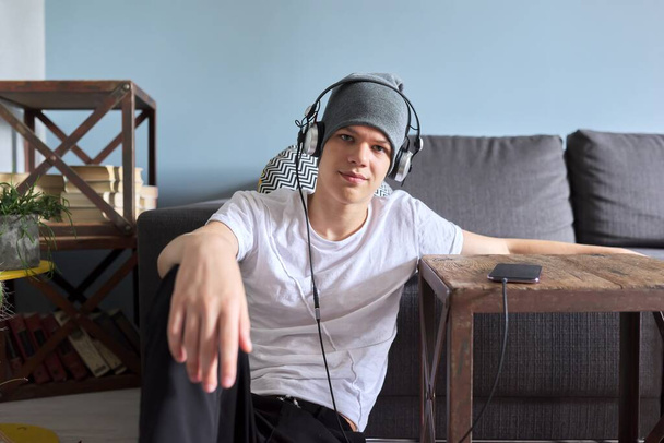 Portrait of hipster teenager in hat with headphones - Foto, Imagen