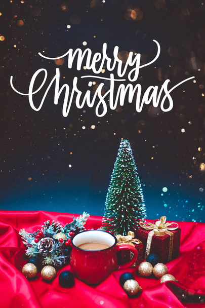 Καφές σε κόκκινο κύπελλο με χριστουγεννιάτικα φώτα και διακόσμηση με κείμενο Καλά Χριστούγεννα - Φωτογραφία, εικόνα