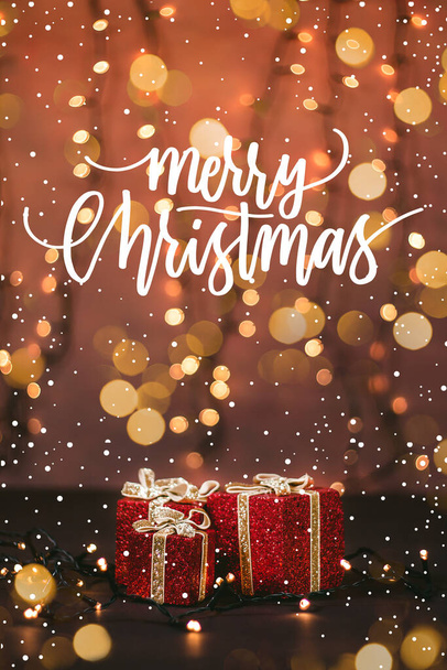 Közelkép egy gyönyörűen becsomagolt ajándékokról, bokeh fényekről és hóról a karácsonyi idézettel - Fotó, kép