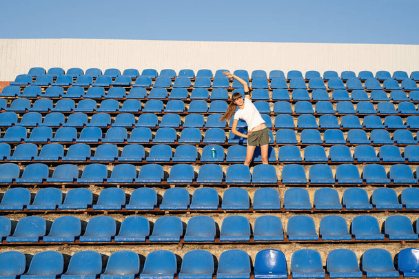 Healthy lifestyle concept. Teenage doing sports alone at the empty stadium - Zdjęcie, obraz