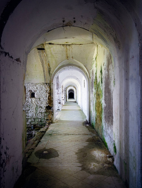 Corredor que liga o forte militar em estado de negligência, paredes sujas de mofo e musgo. Forte Leone, Cima Campo, Belluno, Itália - Foto, Imagem