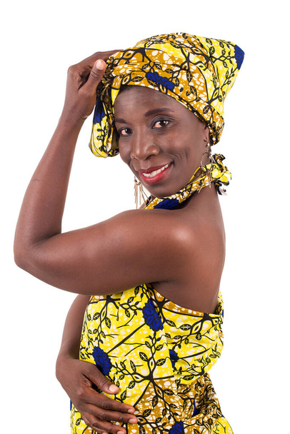 Afrykańska kobieta w żółtym przepasce pozuje szczęśliwie odizolowany na białym tle - Zdjęcie, obraz