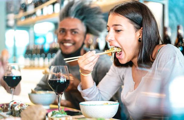 Coppia felice mangiare poke bowl al ristorante sushi bar - Concetto di stile di vita alimentare con i giovani divertirsi insieme a tutti si può mangiare a buffet - Focus selettivo sulla donna con le bacchette - Foto, immagini
