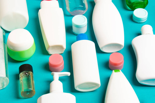 Különböző méretű palackok és befőttesüvegek közelről színes háttéren kozmetikai termékekhez. Arc- és testápolási koncepció másolási hellyel. - Fotó, kép