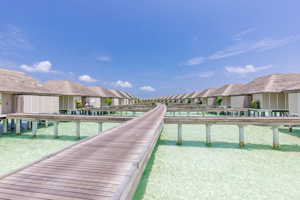 Verbazingwekkend landschap van Malediven strand. Tropisch panorama, luxe watervilla resort met houten pier of steiger. Luxe reisbestemming achtergrond voor zomervakantie en vakantie concept. - Foto, afbeelding