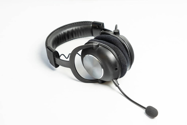 Auriculares inalámbricos negros con un micrófono aislado en blanco - Foto, imagen