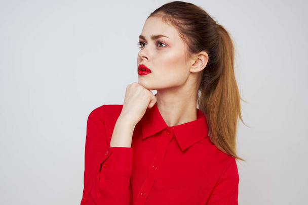 πορτρέτο μιας γυναίκας με κόκκινα χείλη σε ένα πουκάμισο σε ένα ελαφρύ φόντο περικοπεί άποψη μοντέλο μακιγιάζ χτένισμα - Φωτογραφία, εικόνα