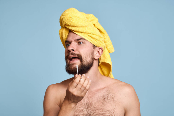 άνδρας με γυμνούς ώμους κίτρινη πετσέτα στο κεφάλι του βαμβακερά μάκτρα υγιεινή φροντίδα - Φωτογραφία, εικόνα