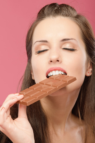 młoda kobieta ukąszeń czekolady - Zdjęcie, obraz