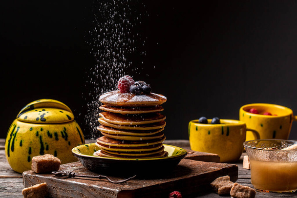 pancakes stack with berries and honey. catering, stack of tasty pancakes on wooden table. - Photo, Image