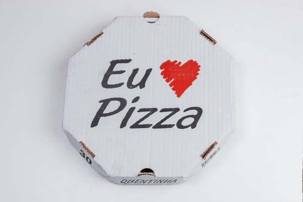 "Szeretem a pizzát" feliratú pizzásdoboz egy fehér asztalon.. - Fotó, kép