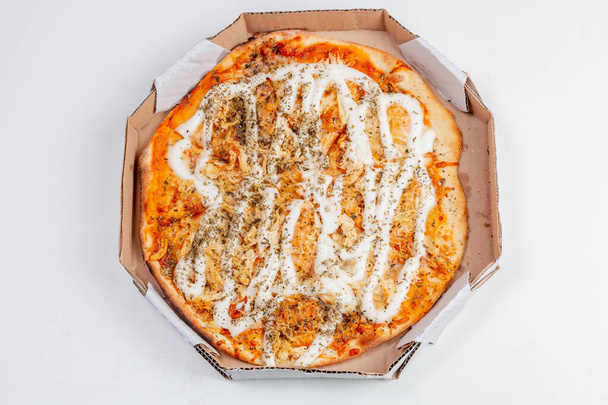 Pizza redonda de pollo con queso catupiry sobre una mesa blanca. Combinación muy común en la cocina brasileña. - Foto, Imagen