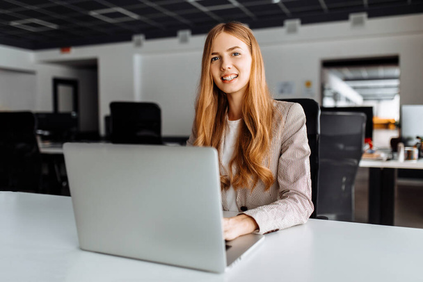 Business young woman sitting at table with laptop in office, business concept - Photo, Image