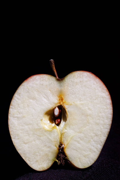 Az alma felének levágása fekete alapon izolált pedikűrrel  - Fotó, kép