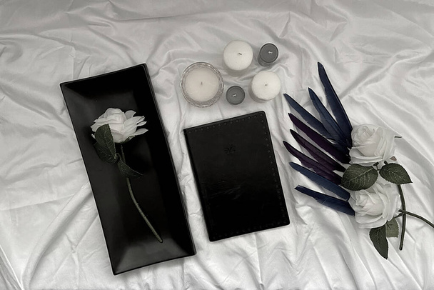 valkoinen tausta musta höyhenet ja ruusut ja tyhjä kirja - Valokuva, kuva