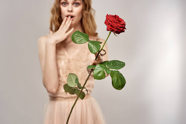 Femme élégante avec des épines de rose rouge fond clair fleurs romance - Photo, image