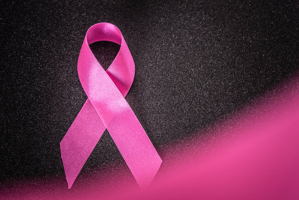 Cinta rosa sobre fondo negro brillo, Símbolo de conciencia de cáncer de mama, conciencia de cáncer abdominal y octubre Fondo de día rosa, día mundial del cáncer. - Foto, imagen