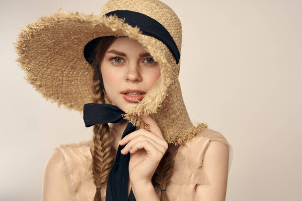 mignonne fille en paille chapeau avec ruban noir et robe sur fond beige vue recadrée - Photo, image