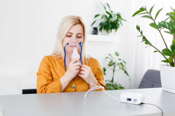 Giovane donna che utilizza nebulizzatore per l'asma e le malattie respiratorie casa - Foto, immagini