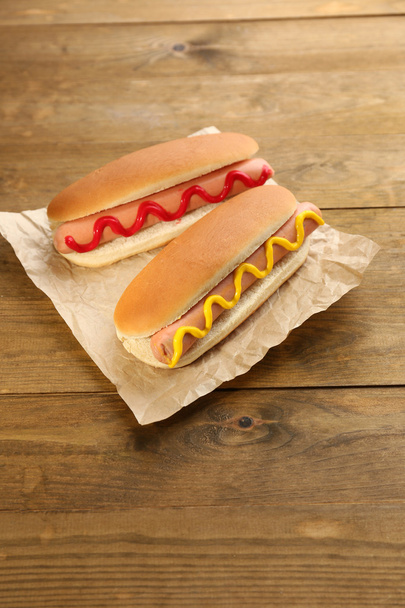 Tasty hot dogs on wooden table - Fotoğraf, Görsel