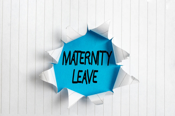 Writing note showing Maternity Leave. Business photo showcasing a leave of absence for an expectant or a new mother Rolled ripped torn cardboard above a wooden classic table. - Photo, Image