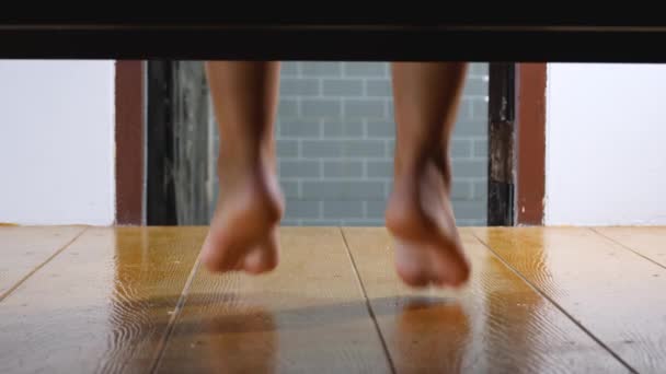 Kobiece stopy pod łóżkiem rano w domu - Materiał filmowy, wideo