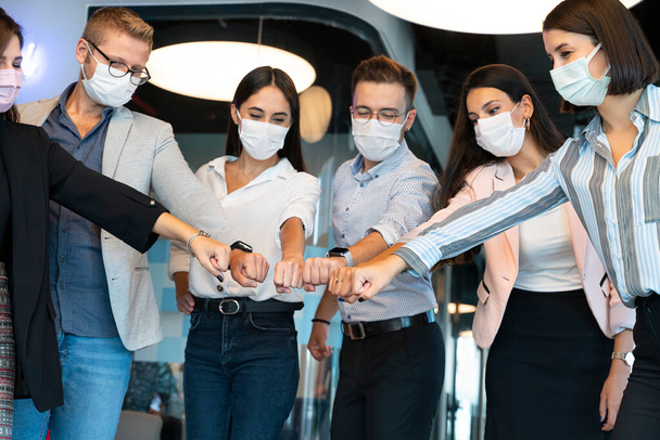 en la pandemia la gente se saluda en el trabajo con una nueva forma normal - Foto, imagen