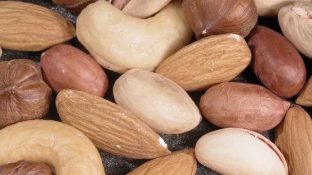 Een verscheidenheid aan close-up noten. Amandelen, hazelnoten, pistachenoten, cashewnoten en pinda 's. - Video