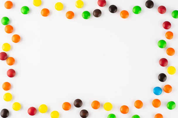 Colorful candies over white background with room for text. - 写真・画像