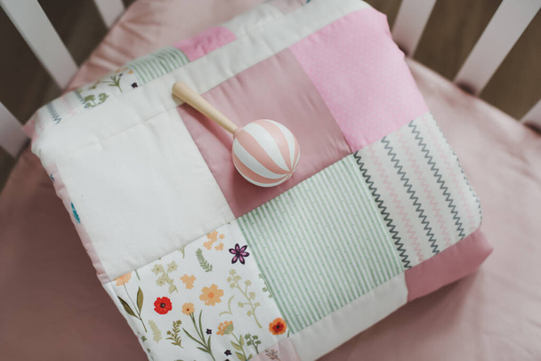 Cozy baby cot with pink patchwork blanket.  Bedding and textile for children nursery. Nap and sleep time - Foto, imagen