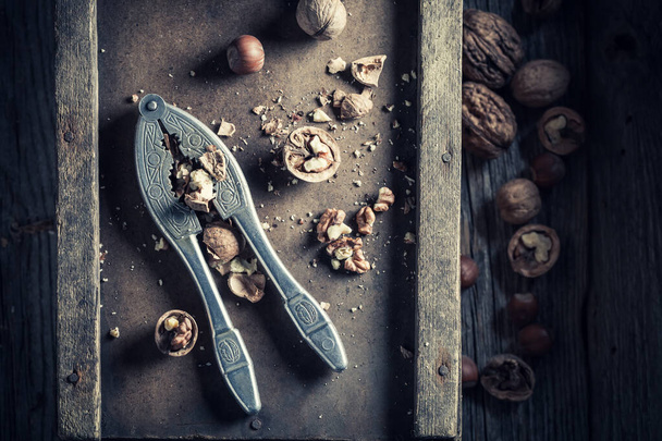 Top view of nuts and old nutcracker on wooden table - Foto, imagen