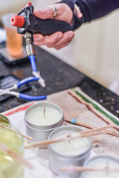 Tvůrčí zaměstnání svíčky ukazující nalití tekutého vosku do sklenic - Fotografie, Obrázek