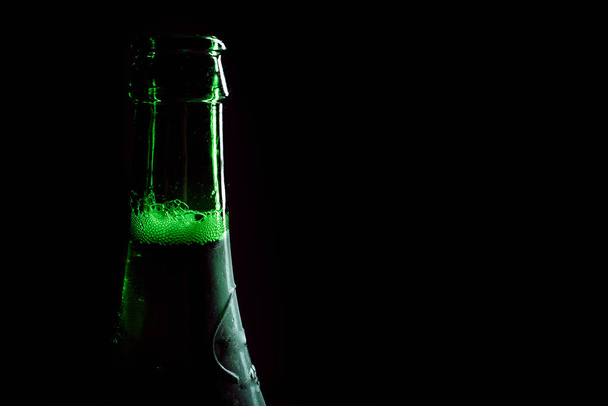 Frasco de cerveja verde cheio em um fundo preto - Foto, Imagem