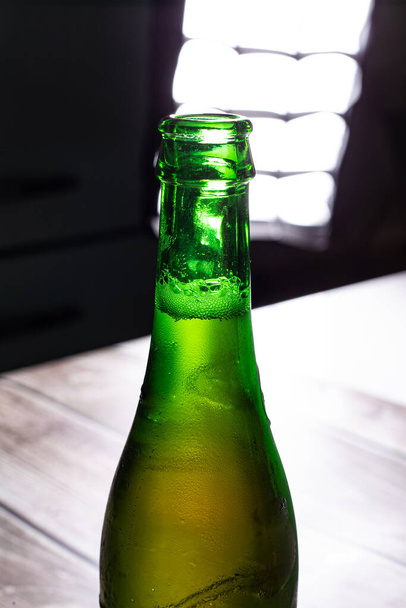 Zöld sörösüveg teljes háttérvilágítás egy fa háttér - Fotó, kép