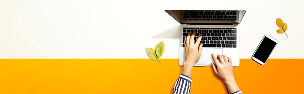 Őszi levelek személy segítségével egy laptop számítógép - Fotó, kép