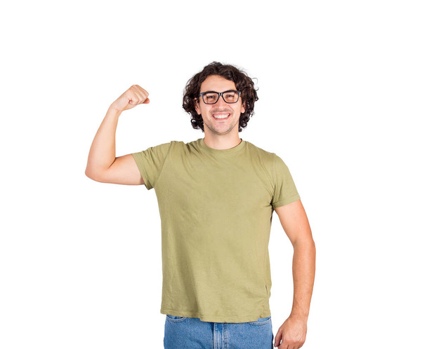 Radostný mladý muž ohýbající biceps, představte si superschopnost. Ten šprt nosí brýle, ukazuje svou svalovou sílu a usmívá se do kamery. Osobní rozvoj, moc a motivační koncepce. - Fotografie, Obrázek