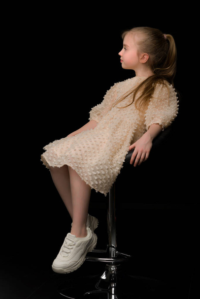 A profile portrait of a pensive little girl.On a black background. - Photo, Image