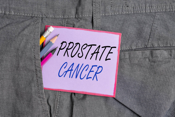 Prostat kanserini gösteren bir mesaj. Erkek üreme sisteminde kanserin kavramsal fotoğraf gelişimi. Yazım ekipmanları ve mor not kağıtları erkek iş pantolonlarının cebinde.. - Fotoğraf, Görsel