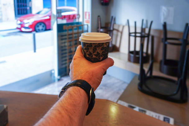 Pincér kezében újrahasznosított kartondoboz forró kávéval menni - Fotó, kép