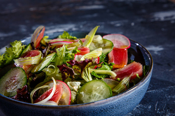 Insalata di foglie di lattuga, tonno fritto, cetrioli e ravanelli è sul piatto - Foto, immagini