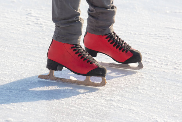 pieds en patins rouges sur une patinoire. passe temps et loisirs. sports d'hiver - Photo, image