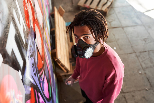 Street artist painting colored graffiti - 写真・画像